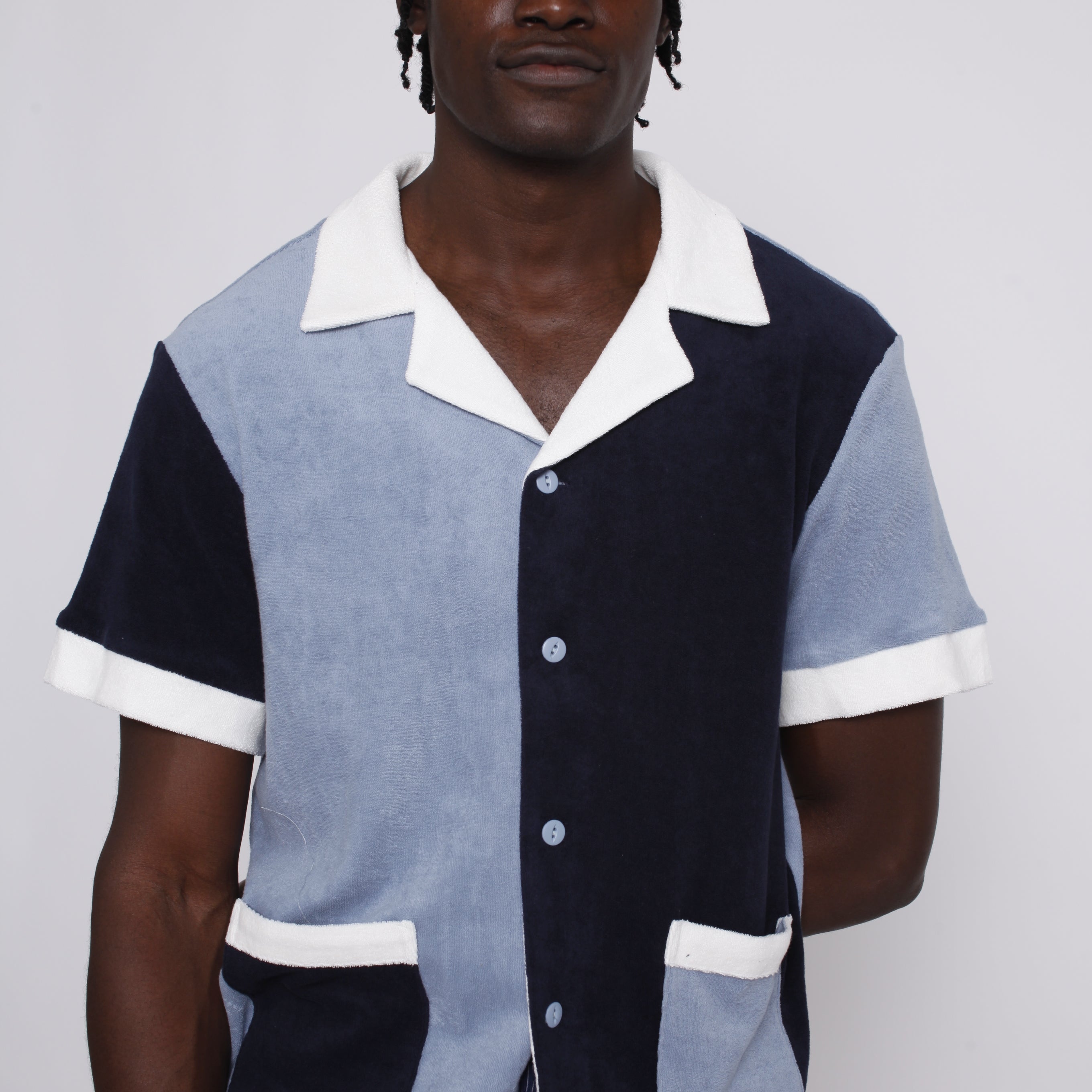 male model wearing shirt with tombolo hat and blue pants