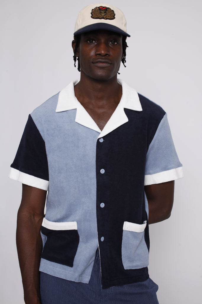 male model wearing shirt with tombolo hat and blue pants
