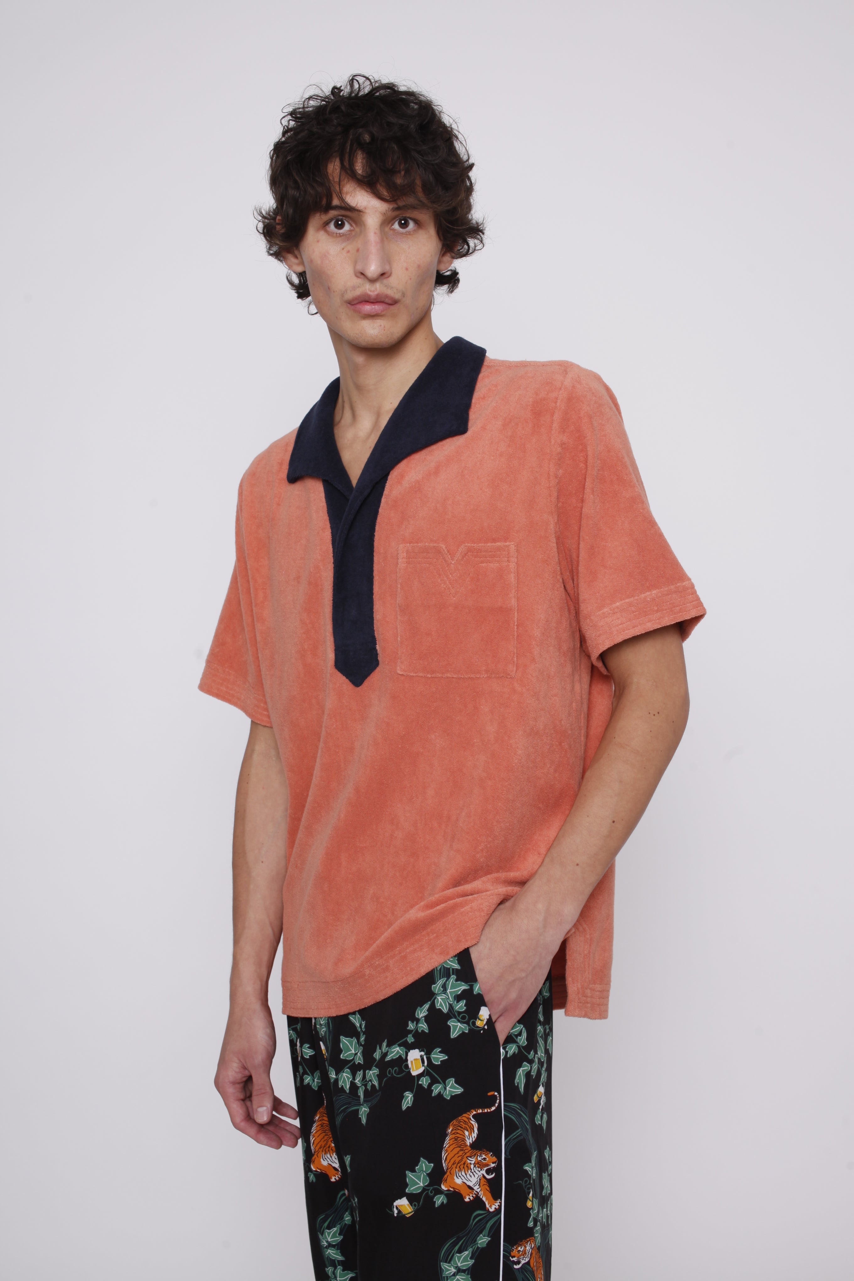 male model wearing polo in photo studio alone with easy going Crouching Tiger, Hidden Beverage pants