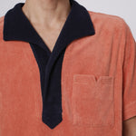Close up of navy collar and apricot v cut pocket on male model
