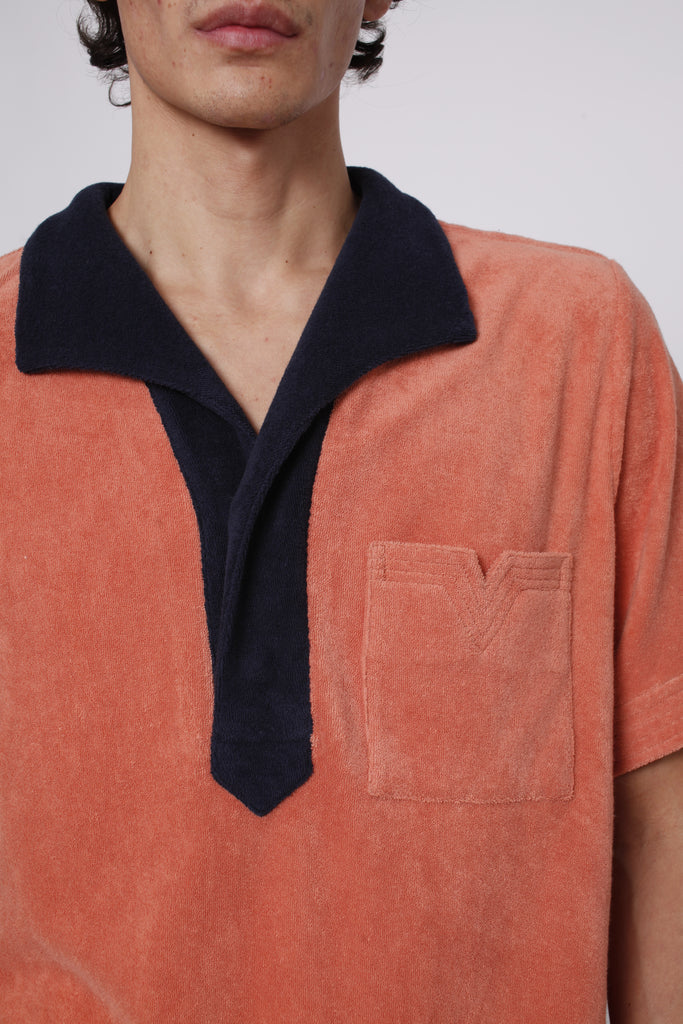 Close up of navy collar and apricot v cut pocket on male model