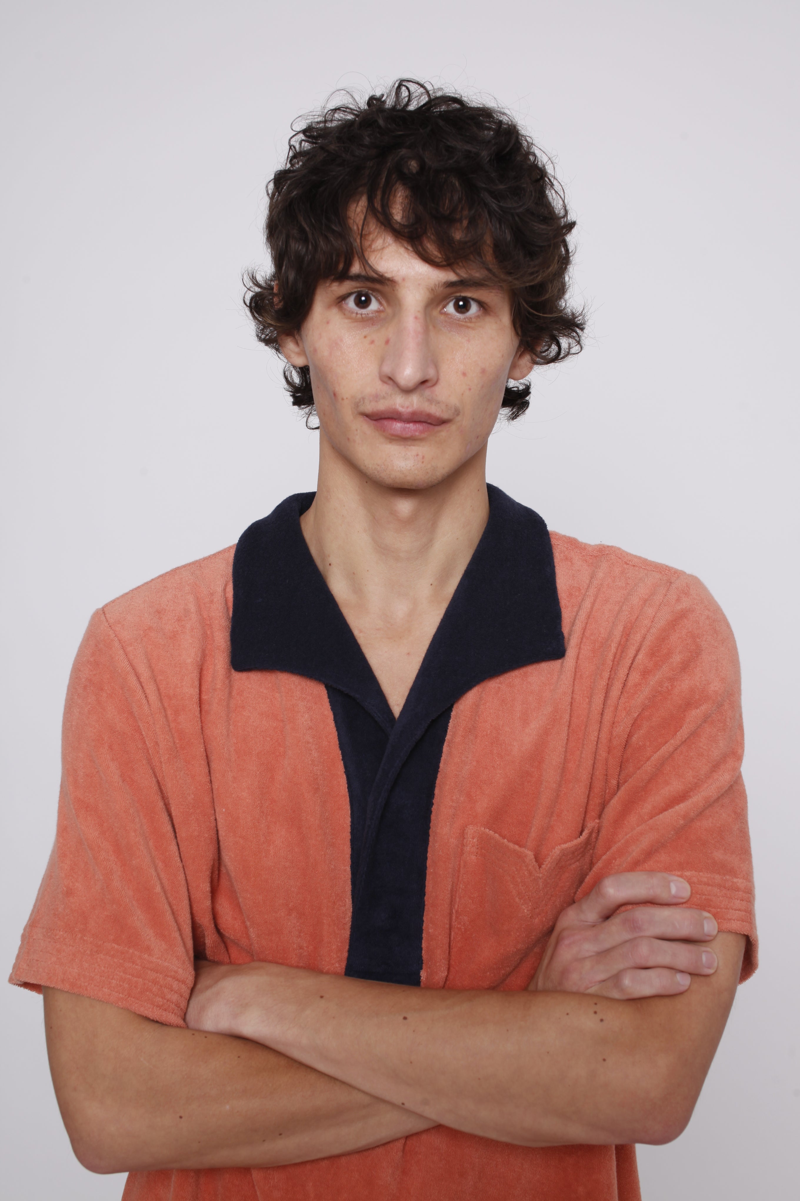 male model wearing polo with arms crossed