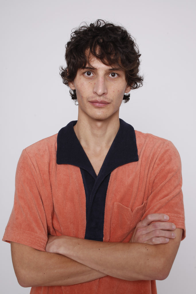 male model wearing polo with arms crossed