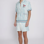 Male model wearing swim trunks with matching tombolo cabana and hat