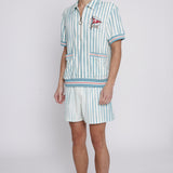 Male model wearing swim trunks with matching tombolo cabana and hat