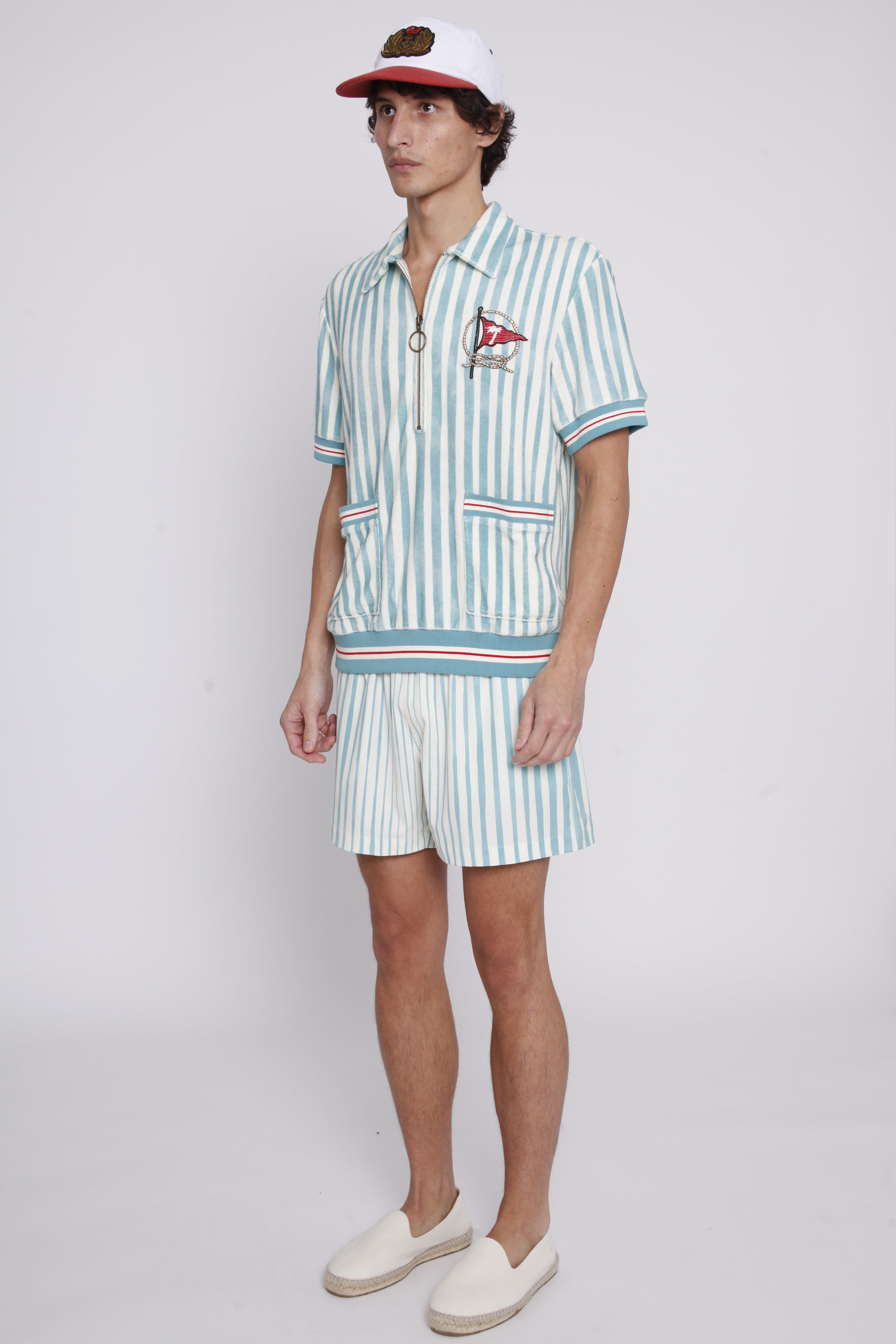 Male model wearing swim trunks with matching tombolo cabana and hat