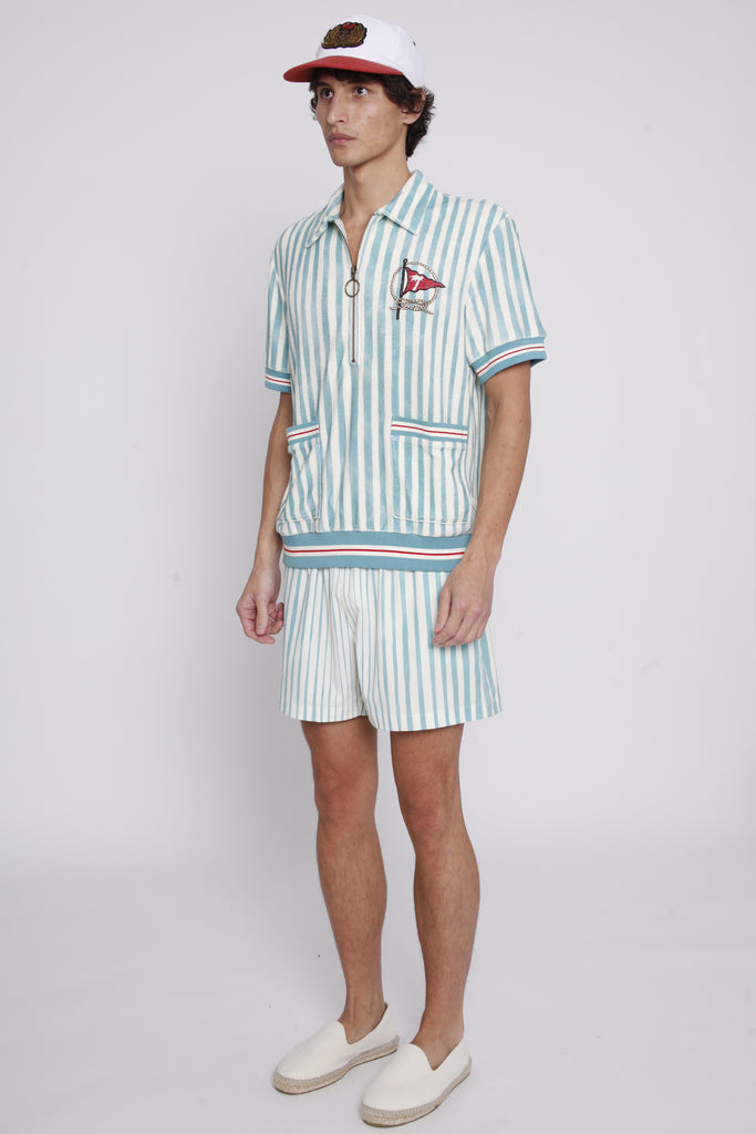 Male model wearing swim trunks with matching tombolo cabana and hat