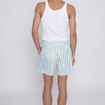 Male model looking over his shoulder in trunks with a white tank