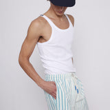Male model wearing cap with white tank top and tombolo blue striped swim trunks