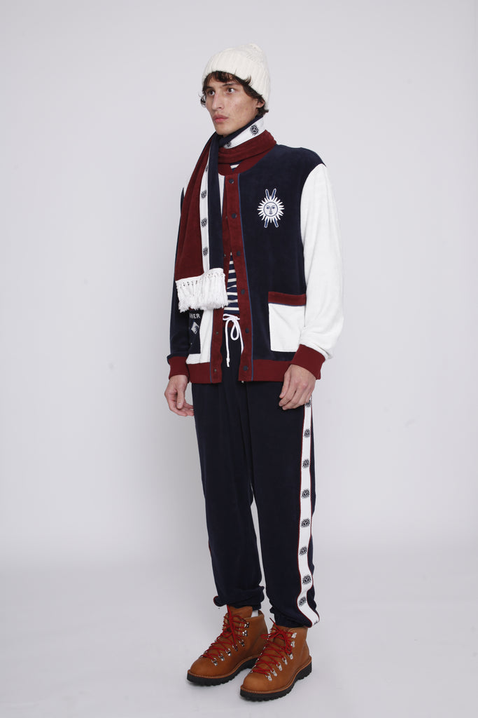 Male model in full set also wearing a white beanie and boots