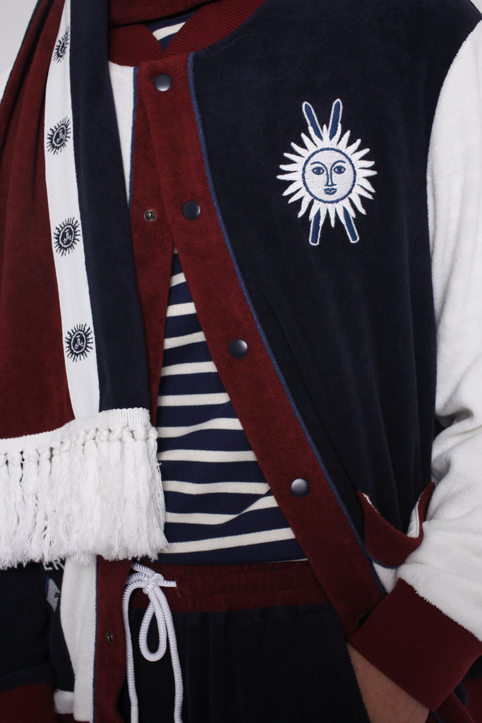 Close up of jacket partially unbuttoned over a navy and white striped shirt on male model