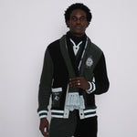 male model gazing at camera in full après ski green set including scarf