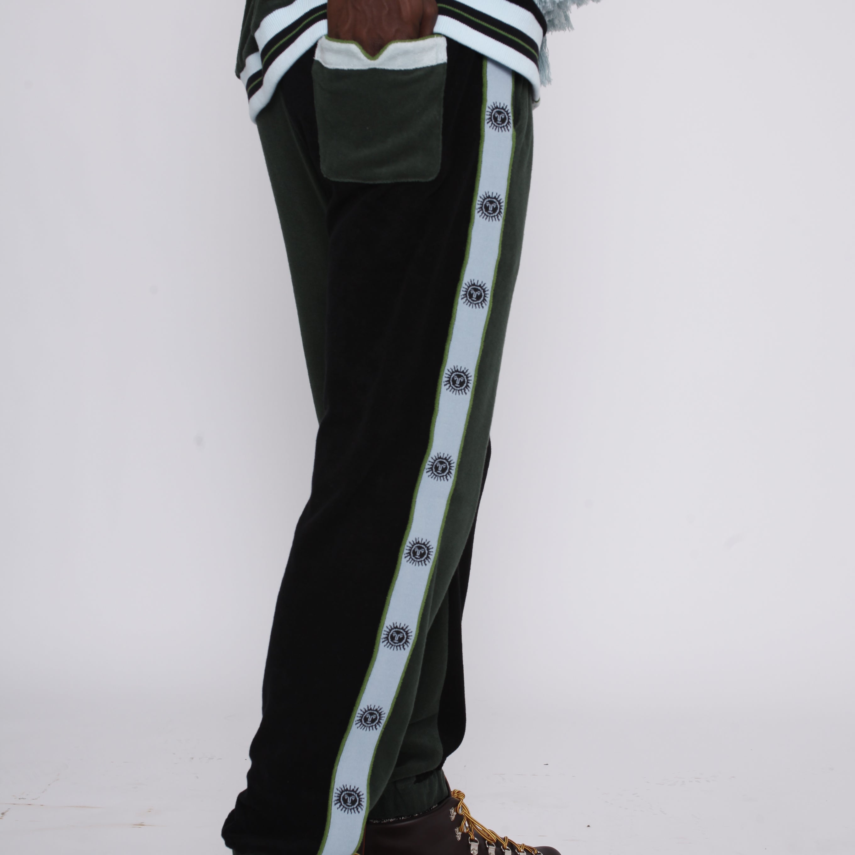 male model standing in full green apres ski set with hand in back pocket