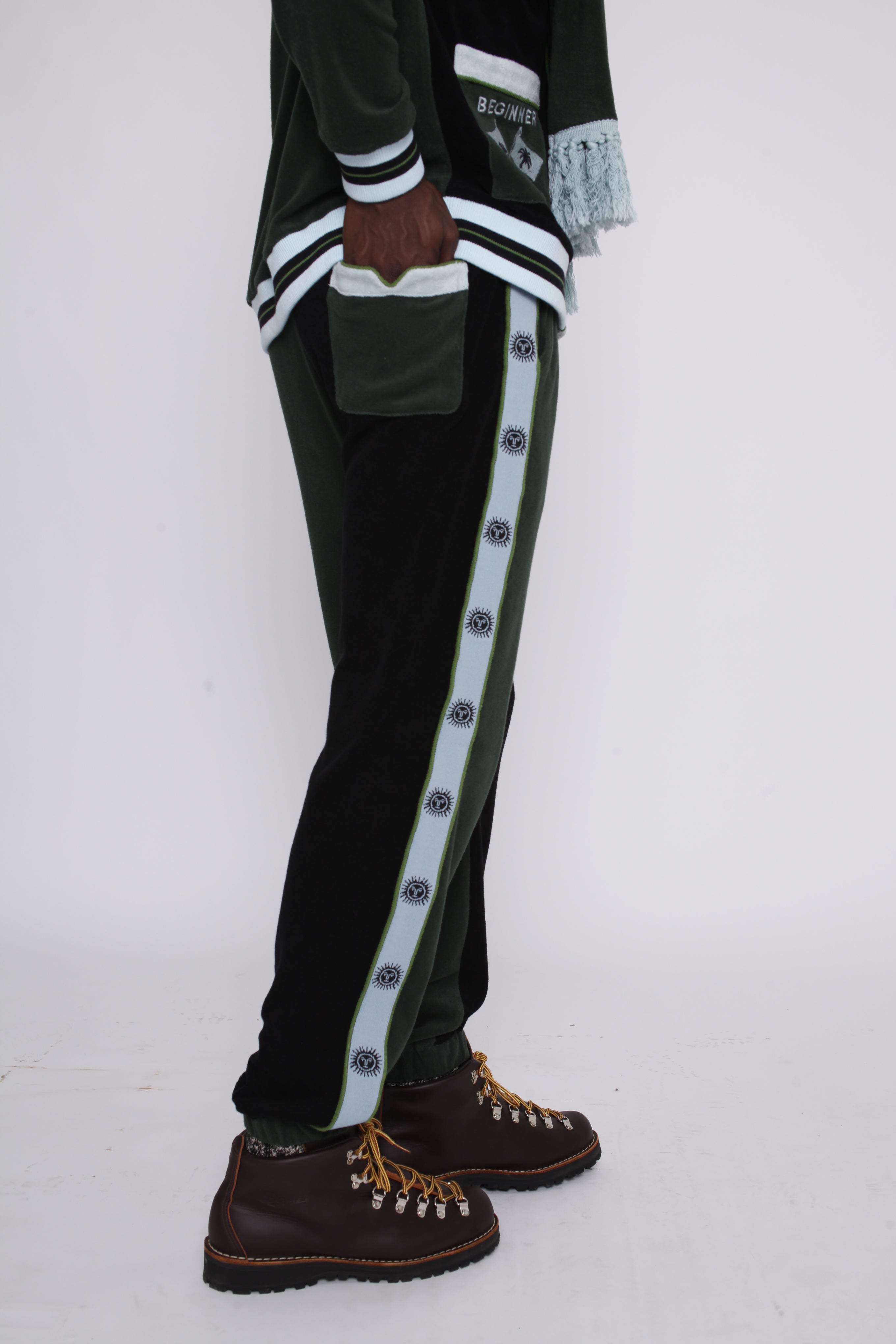 male model standing in full green apres ski set with hand in back pocket