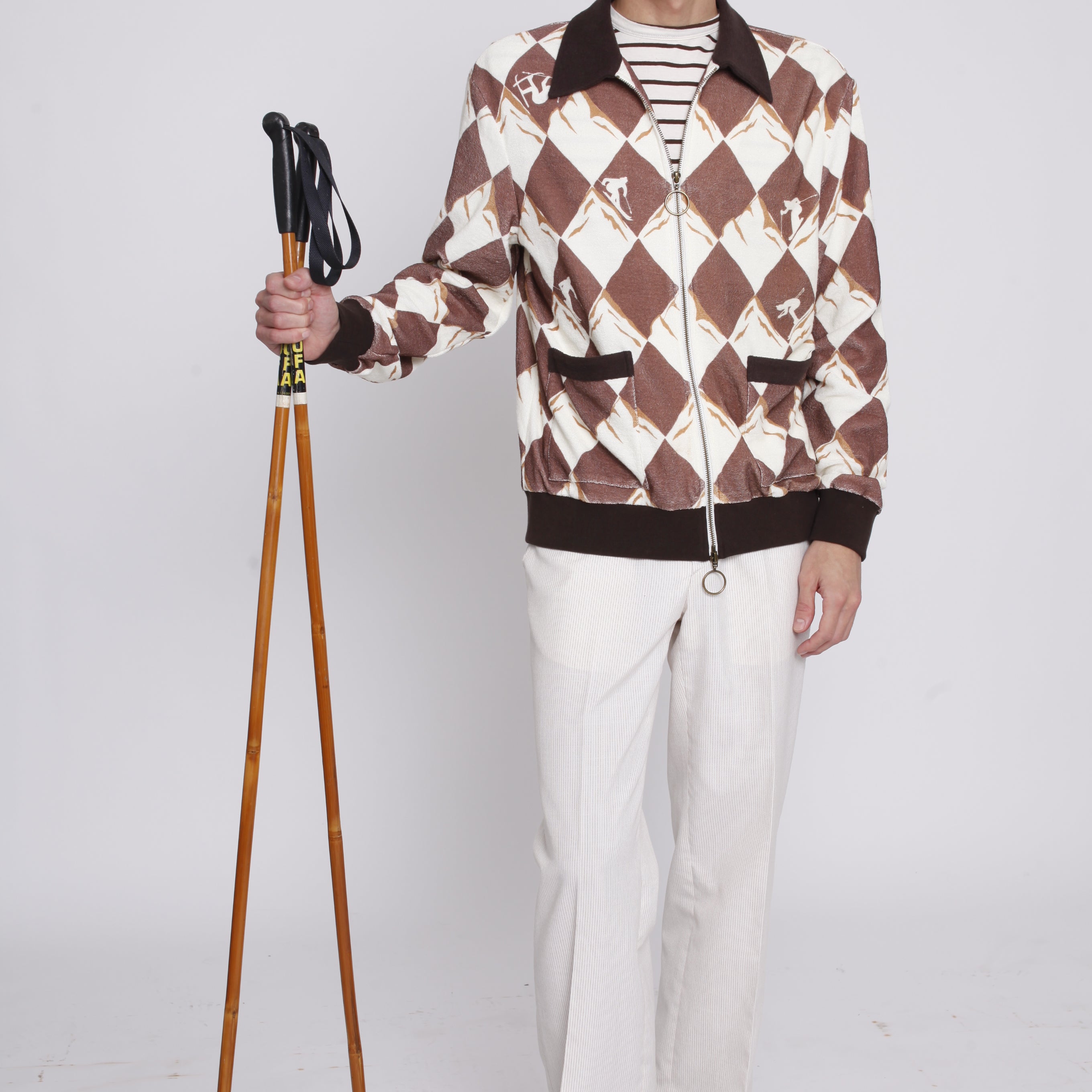 Man holding ski poles stares at camera