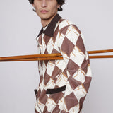 Man poses side on with ski poles under his arm and hand in pocket