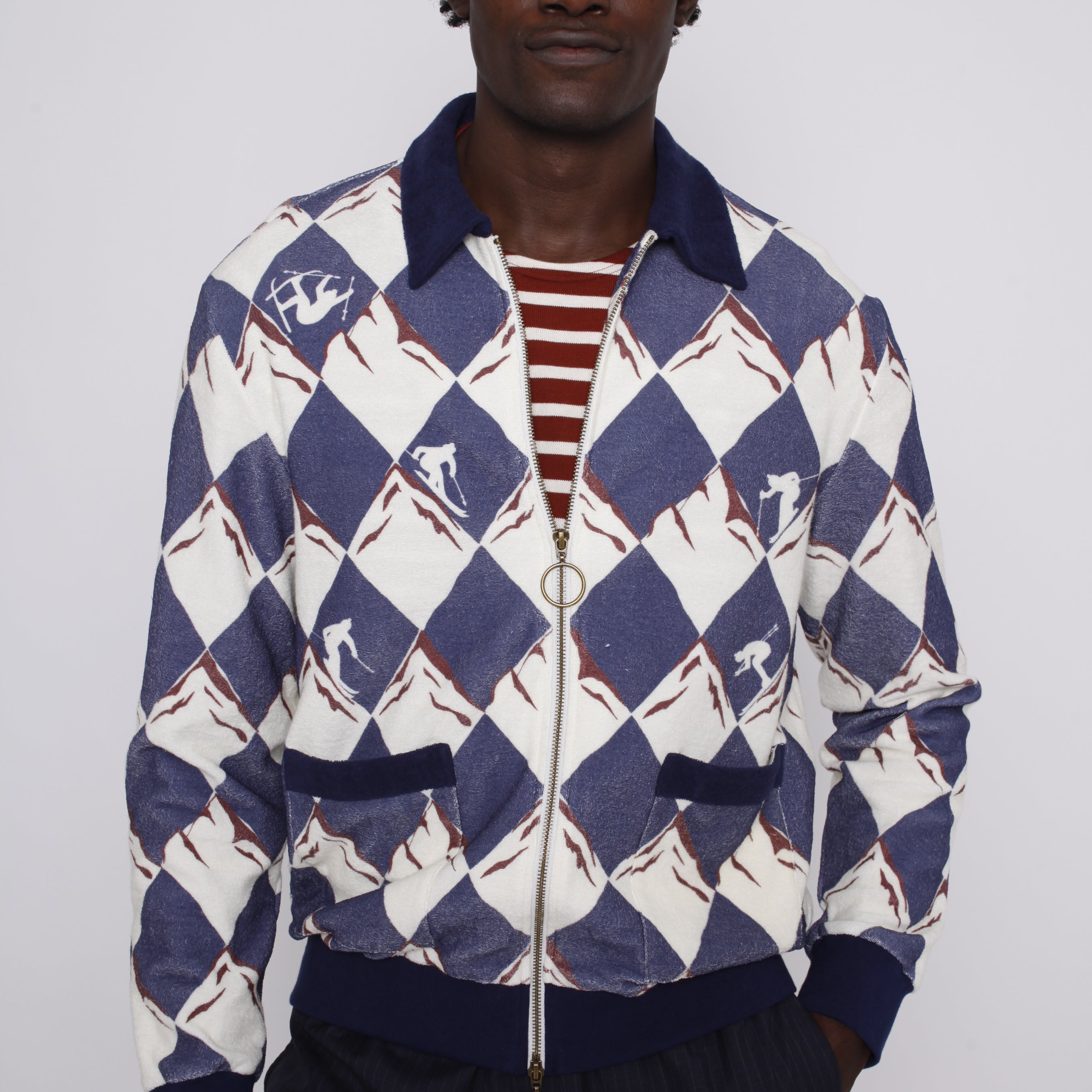 front view of male model in cabana half unzipped over a maroon and white striped tee