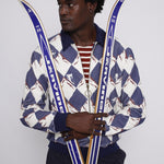 male model holding a pair of skies across his body