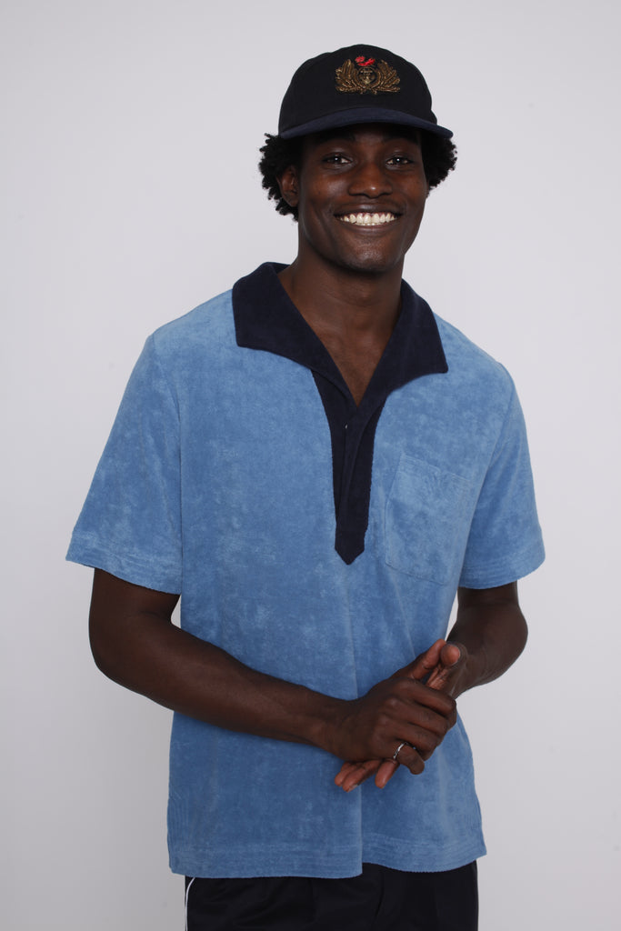 Male model wearing blue polo smiling