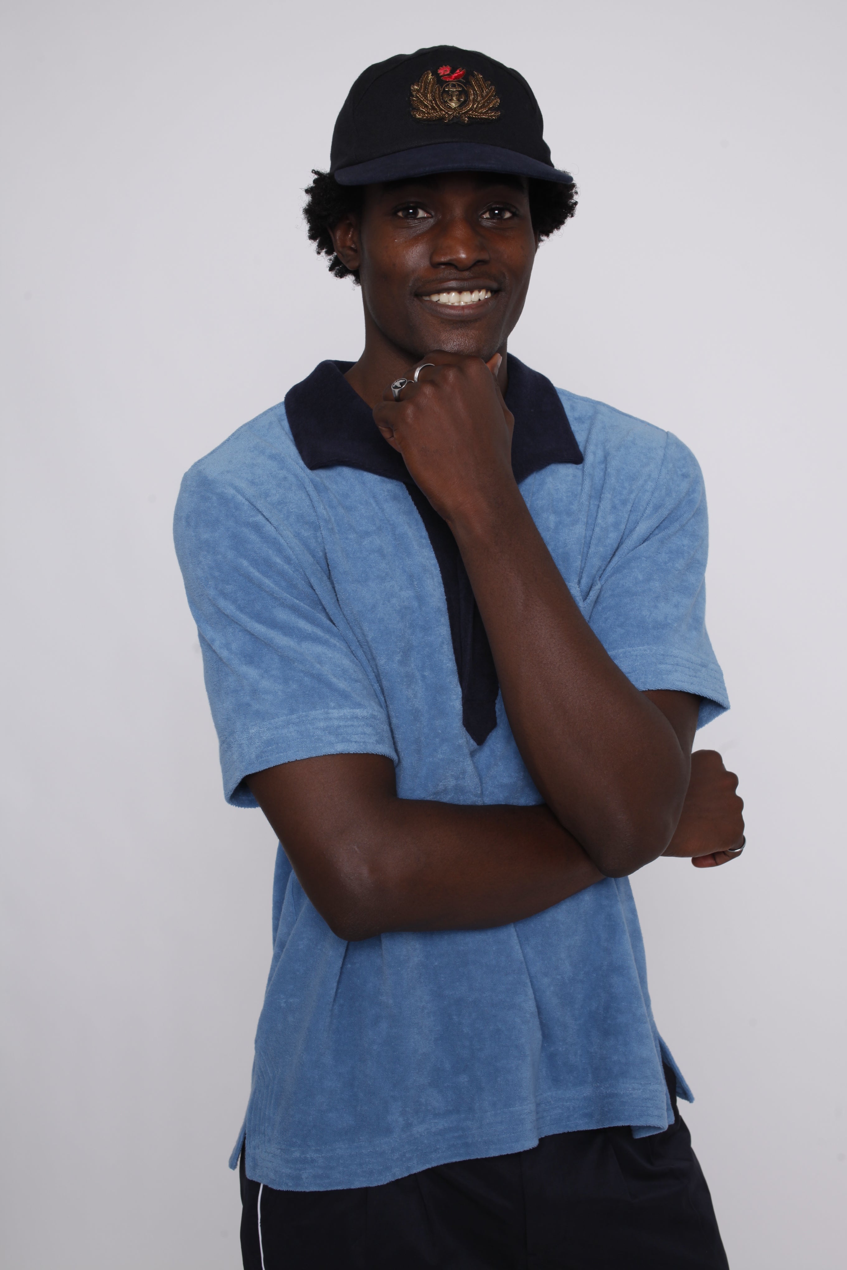 Male model posing in polo with hand under chin