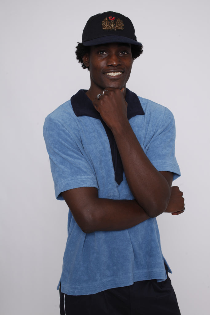 Male model posing in polo with hand under chin