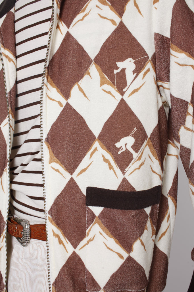 Close up of unzipped jacket showing skier motifs and pocket with black top lining