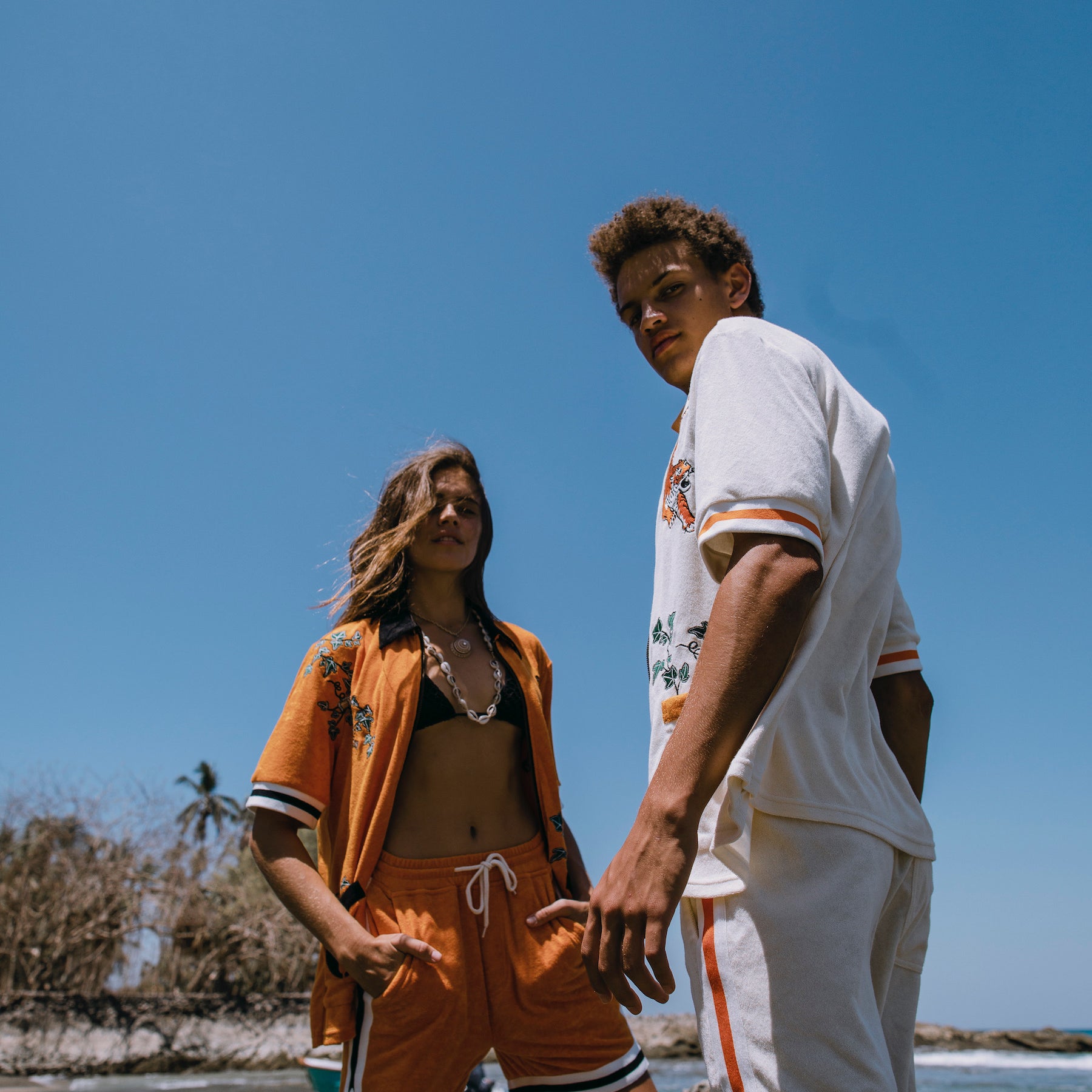 Male and female models both wearing full sets at the beach