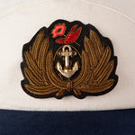 Close up of Hand-embroidered, tarnished gold bullion on felt patch with hand-tooled anchor