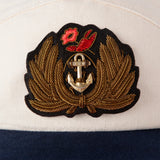 Close up of Hand-embroidered, tarnished gold bullion on felt patch with hand-tooled anchor