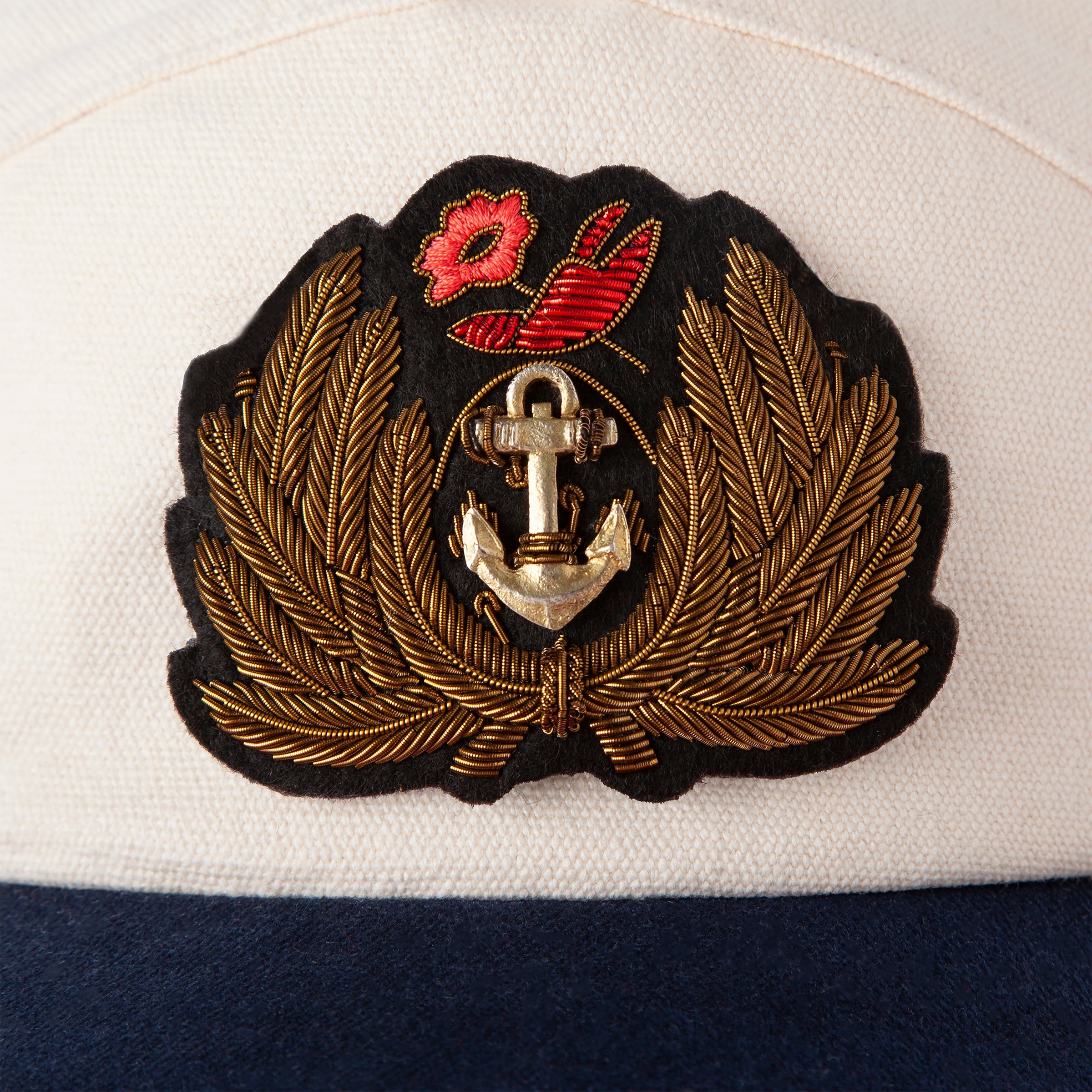 Close up of Hand-embroidered, tarnished gold bullion on felt patch with hand-tooled anchor