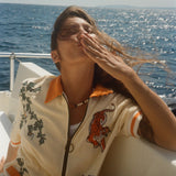 Woman blowing a kiss on a boat, wearing the 'Crouching Tiger' Cabana.
