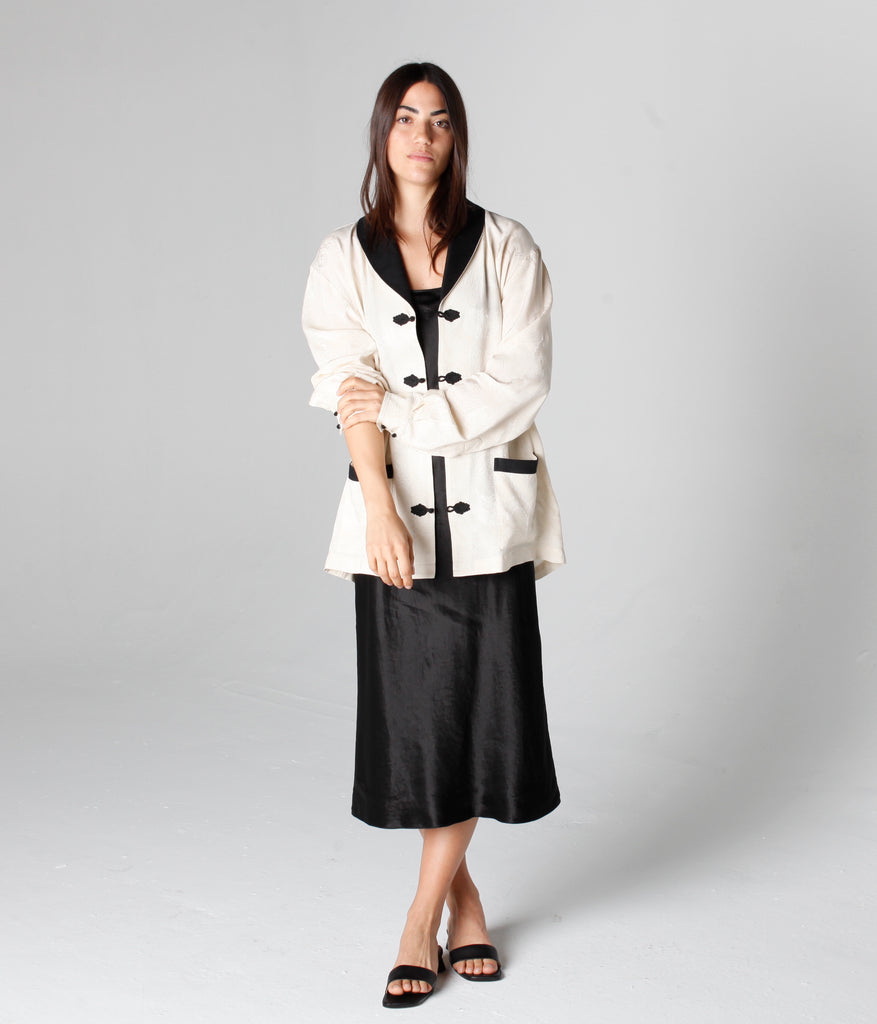 Woman wearing buttoned No Smoking Jacket with one sleeve rolled up