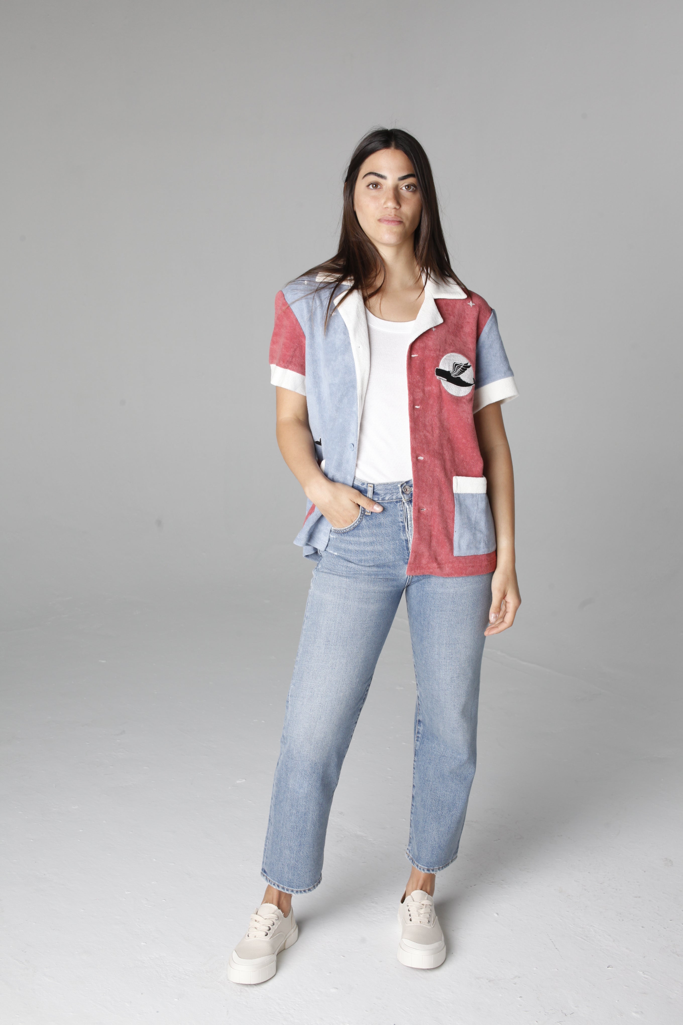 Female model posing in cabana open over a white tee and light wash jeans