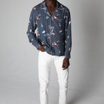 male model wearing top with white pants in a photo studio