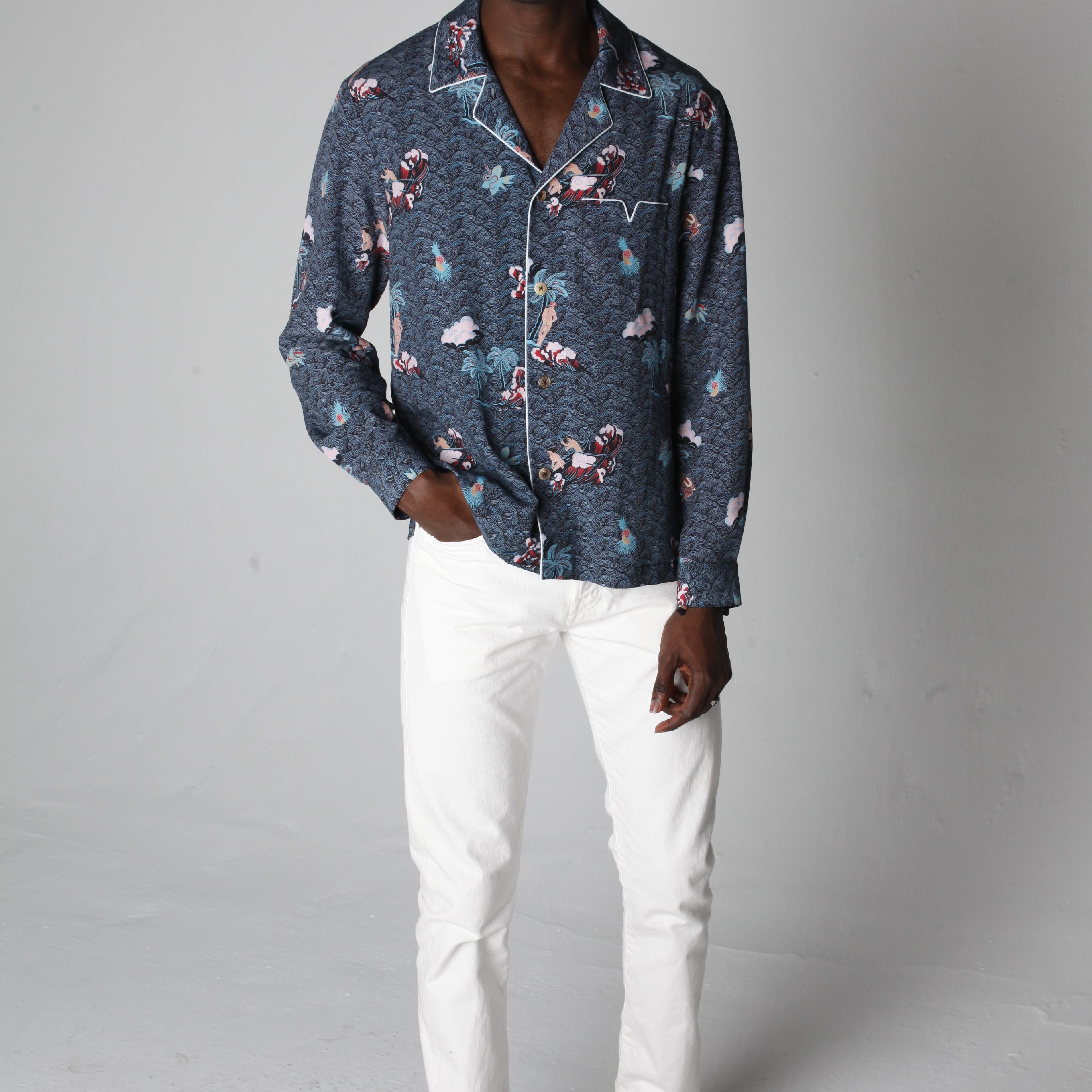 male model wearing top with white pants in a photo studio