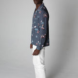 male model wearing top with white pants looking over his right shoulder in a photo studio