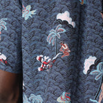 Close up of print showing Eden sitting down next to a palm tree