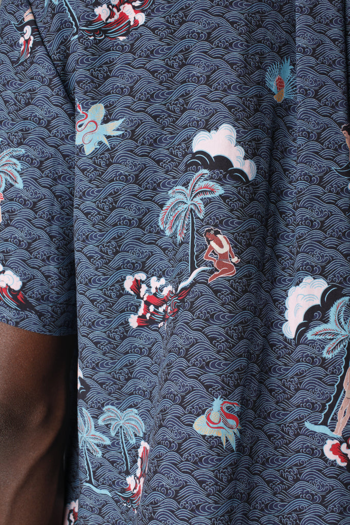 Close up of print showing Eden sitting down next to a palm tree