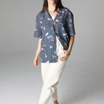 Female model wearing playa of eden shirt with white pants and shoes