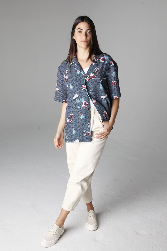 Female model wearing playa of eden shirt with white pants and shoes