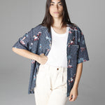 Female model wearing shirt unbuttoned with hand on hip