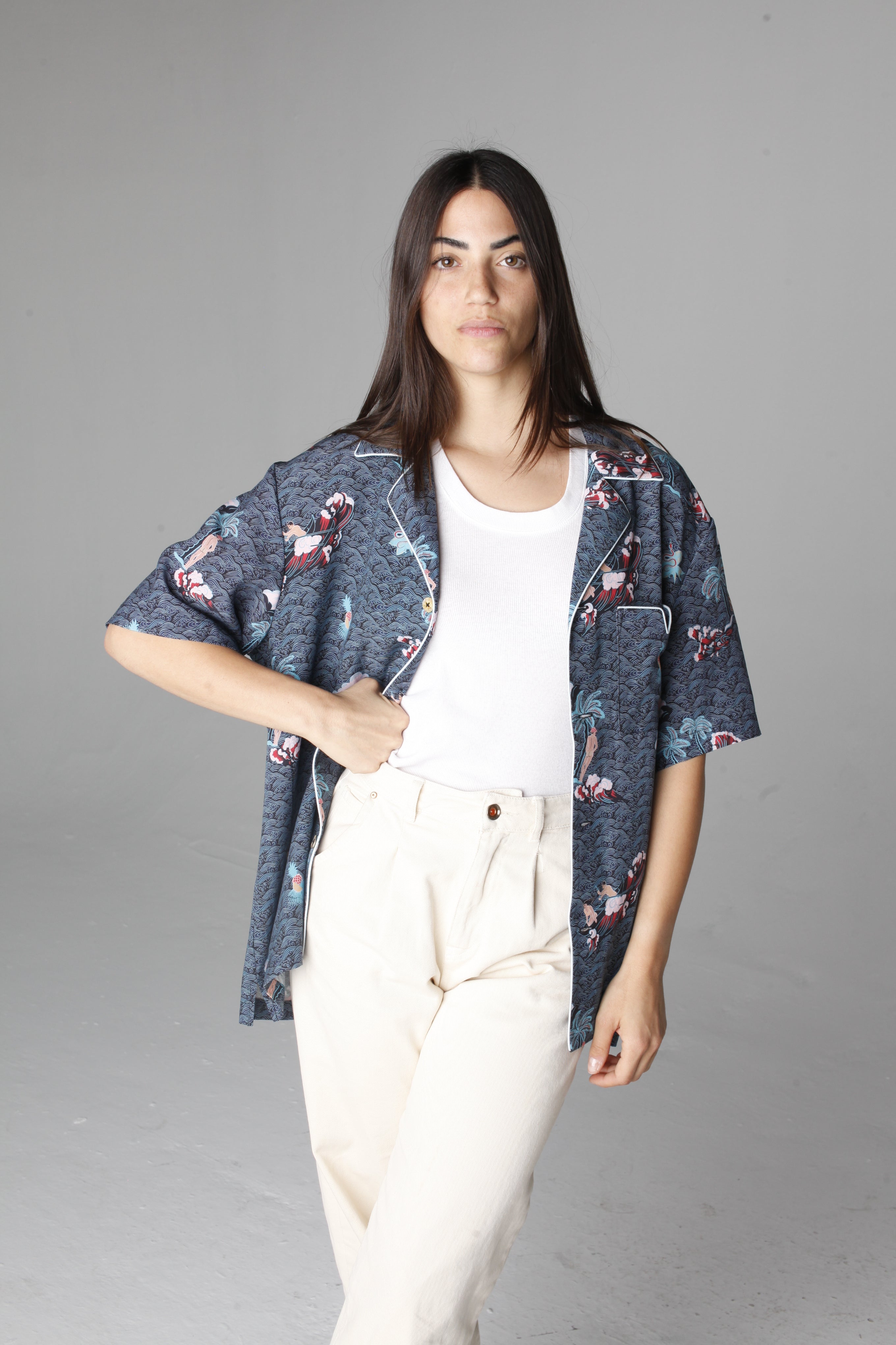 Female model wearing shirt unbuttoned with hand on hip