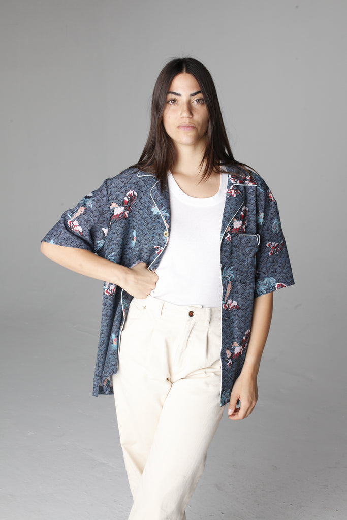 Female model wearing shirt unbuttoned with hand on hip