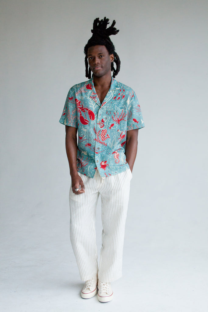 male model wearing top with white pants and shoes