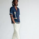 Male model wearing shirt in studio with white pants