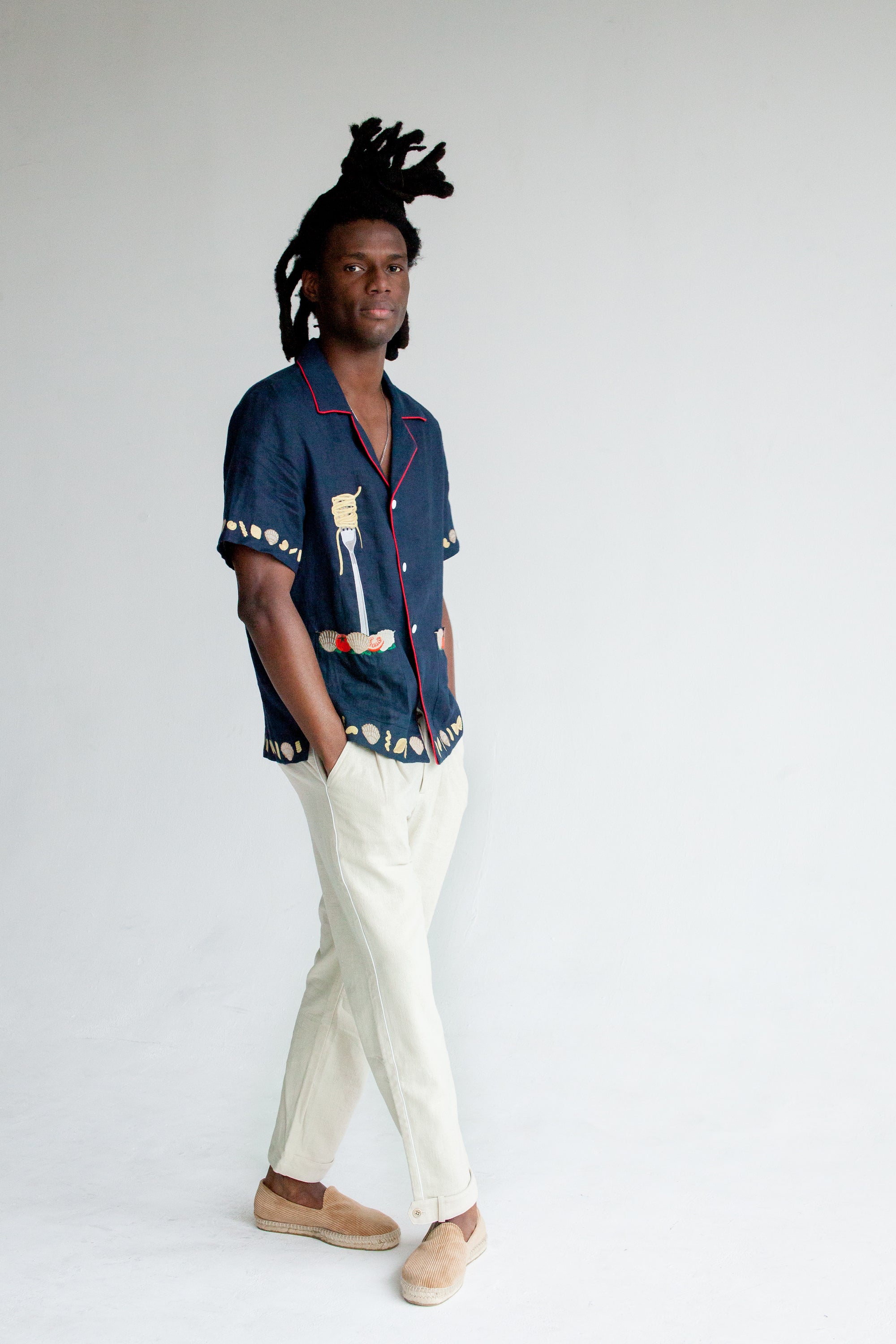 Male model wearing shirt in studio with white pants