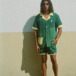 Male model wearing shirt with matching shorts against a wall
