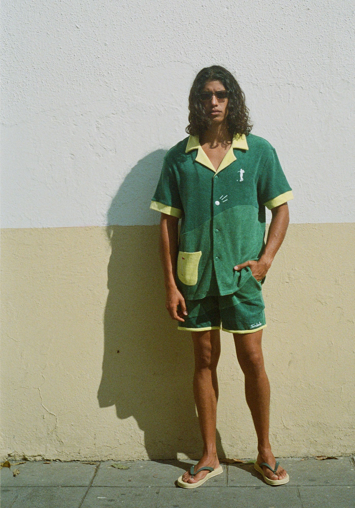 Male model wearing shirt with matching shorts against a wall