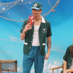 Male model in shirt holding up a toy lobster pretending to get pinched on the nose while a female model looks on