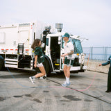 A male and female model jump roping with DSNY workers